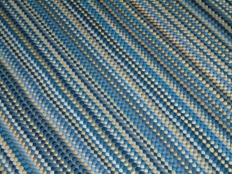 a blue and grey area rug that has small holes on it