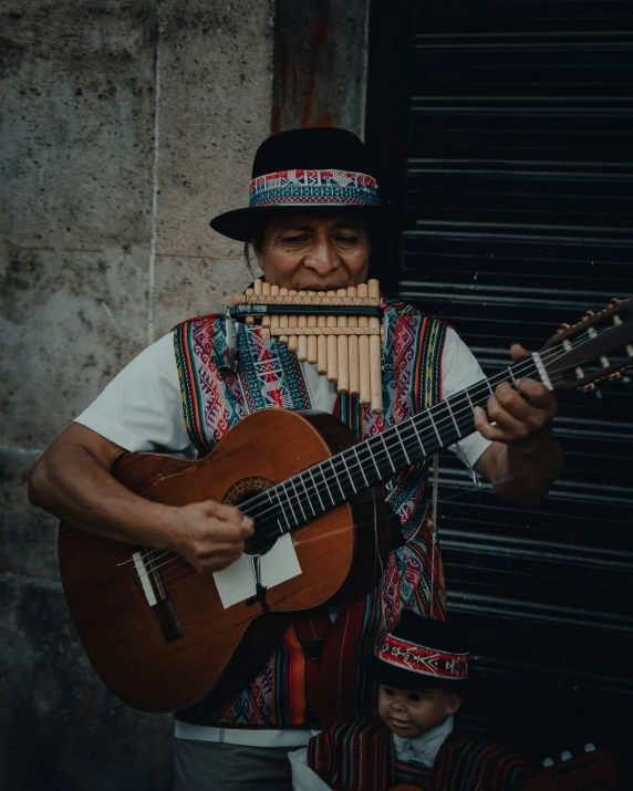 a man playing an instrument with a guitar