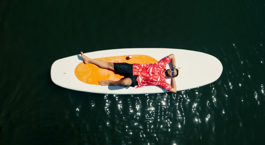 man lying down on a surfboard in the water