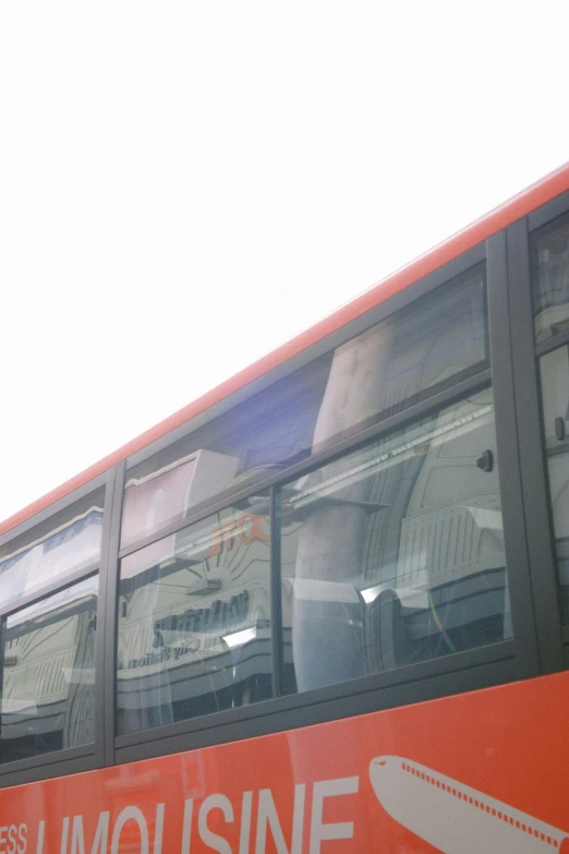 a red double decker bus is parked at the side of a building