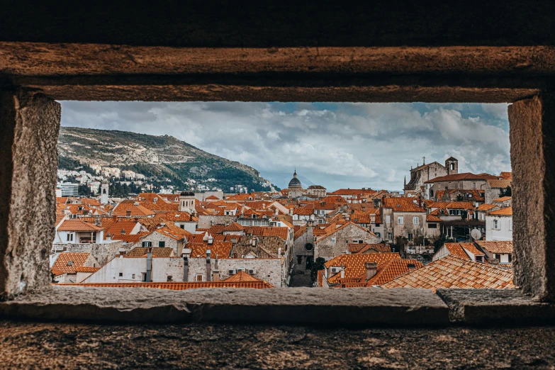 a panoramic view from a wooden frame of red rooftops