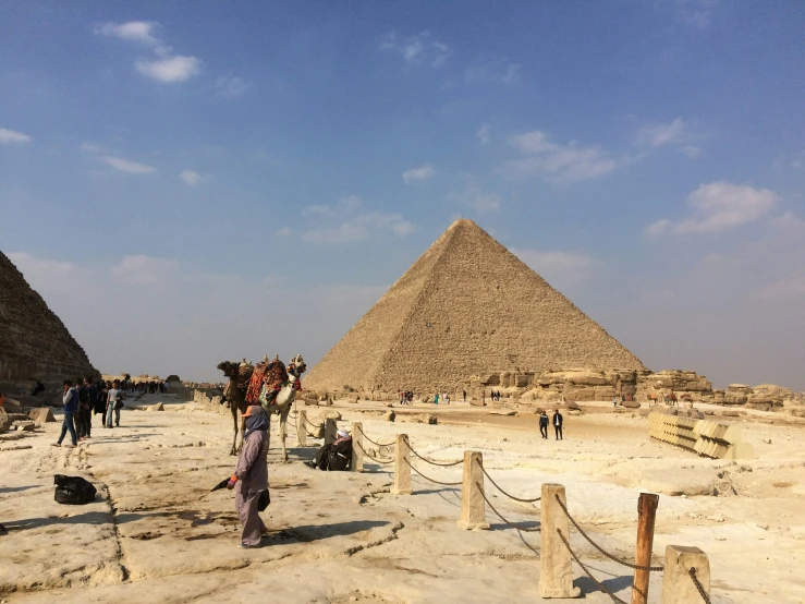 several people are sitting near some pyramids