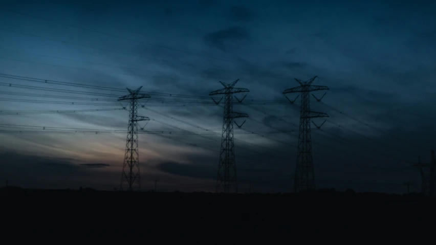 the sky is covered in clouds near some electrical towers