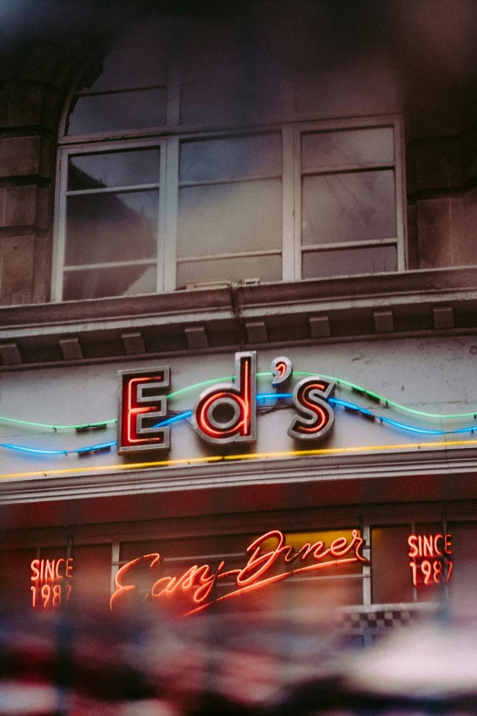 an old building with neon lights in front of it