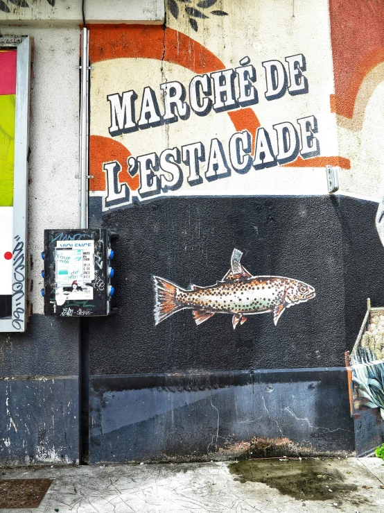 a sign with fish painted on it near a street