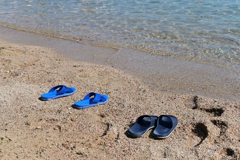 a pair of blue flip flops are on the beach