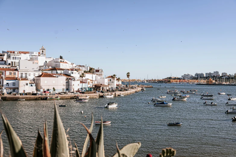 small boats float on the water in the middle of the harbor