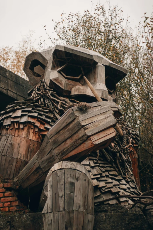 an outdoor sculpture made of pieces of wood in the woods