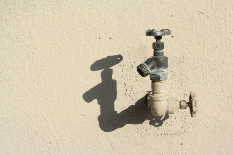 a light on a wall beside a water hose