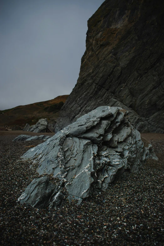 some kind of boulder next to a rocky hillside