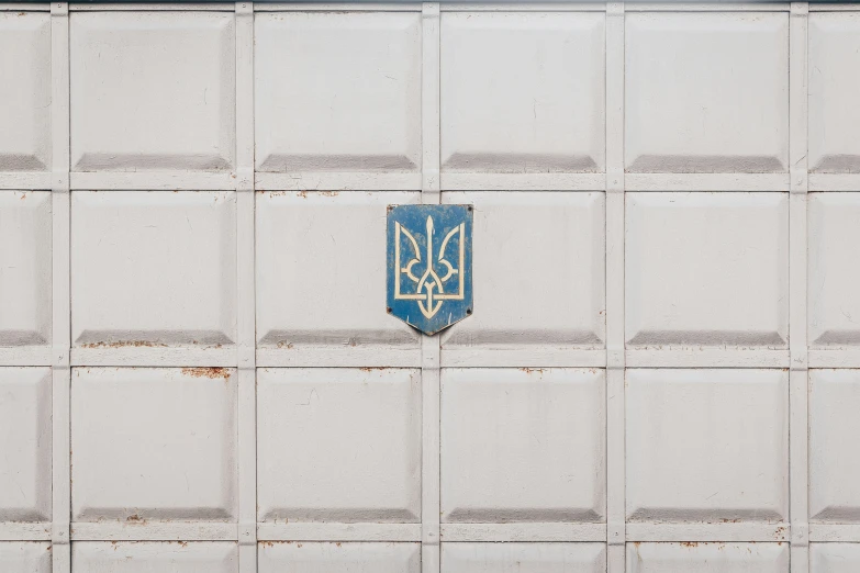 a white tiled wall with the initials and initials written in blue on it