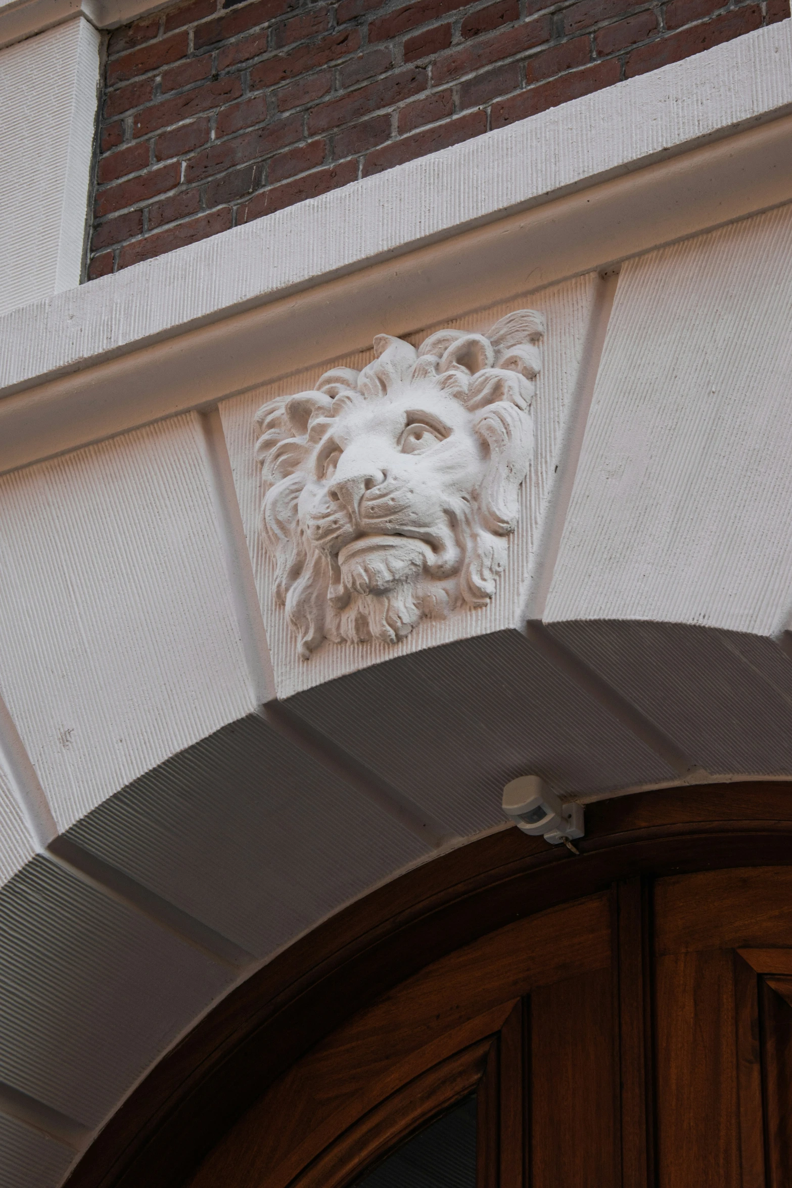 a door with a lion head carving above it