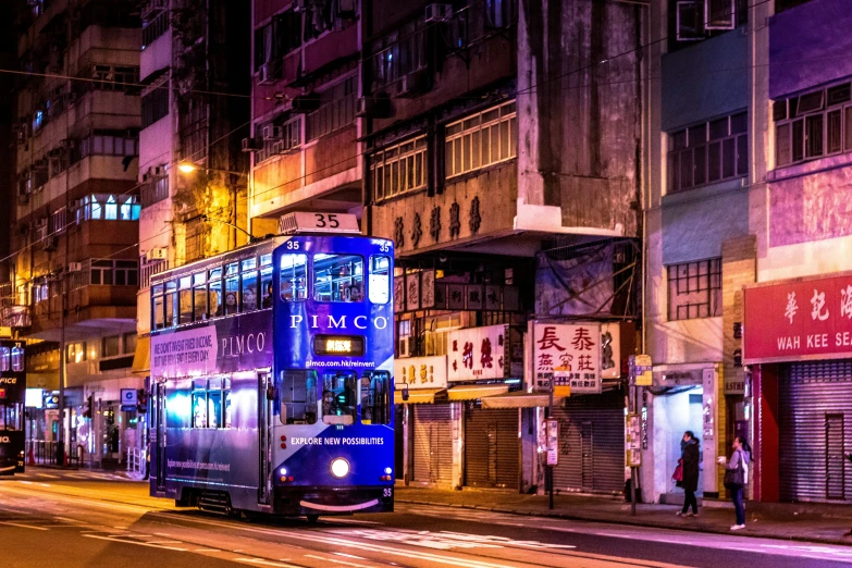 a double decker bus driving down a city street at night