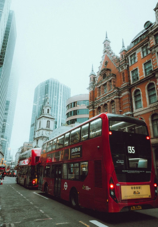 two double decker buses and buildings on a busy city street