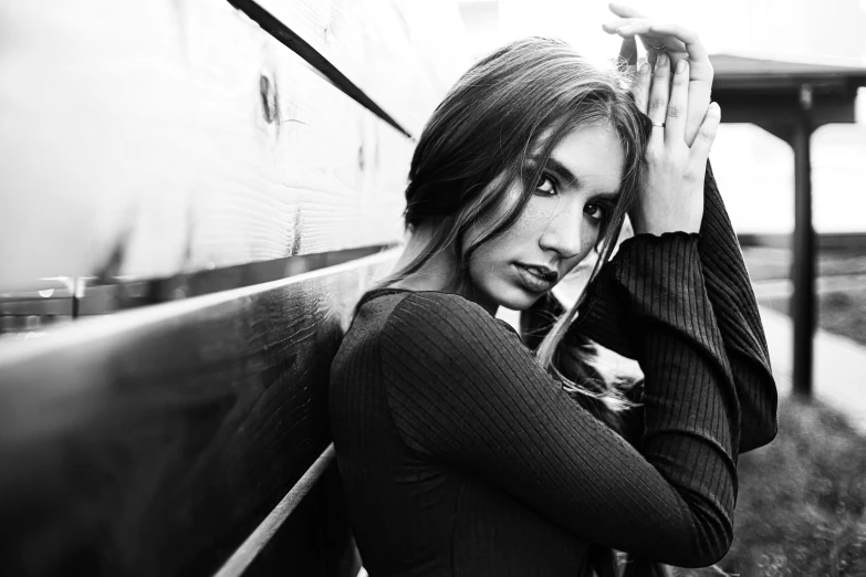 a young woman posing on the side of a train as if for a po