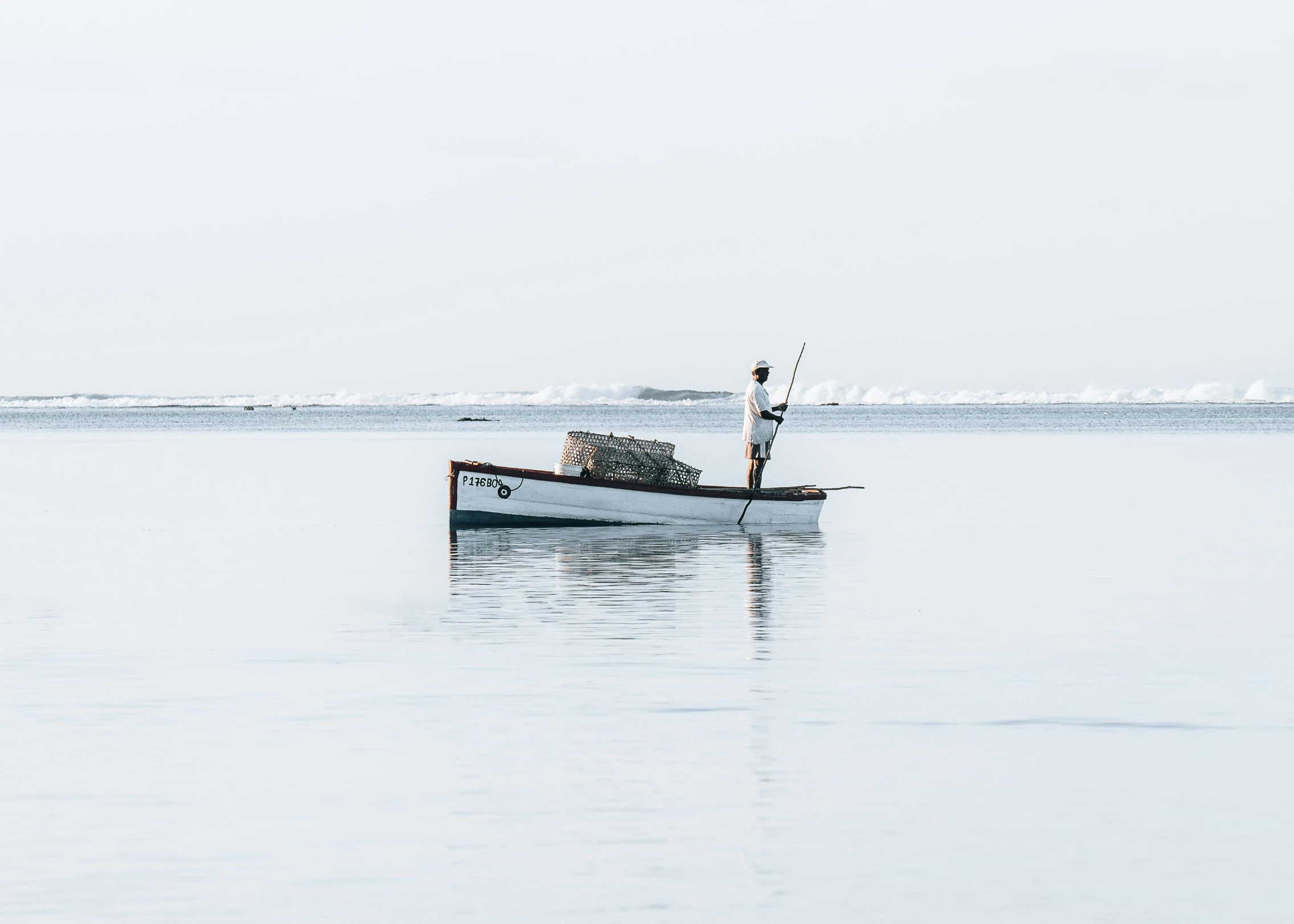 a fishing boat on calm blue water with seagulls in the distance