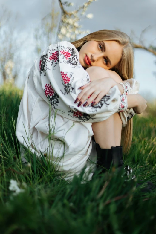 the woman is posing outside in a field