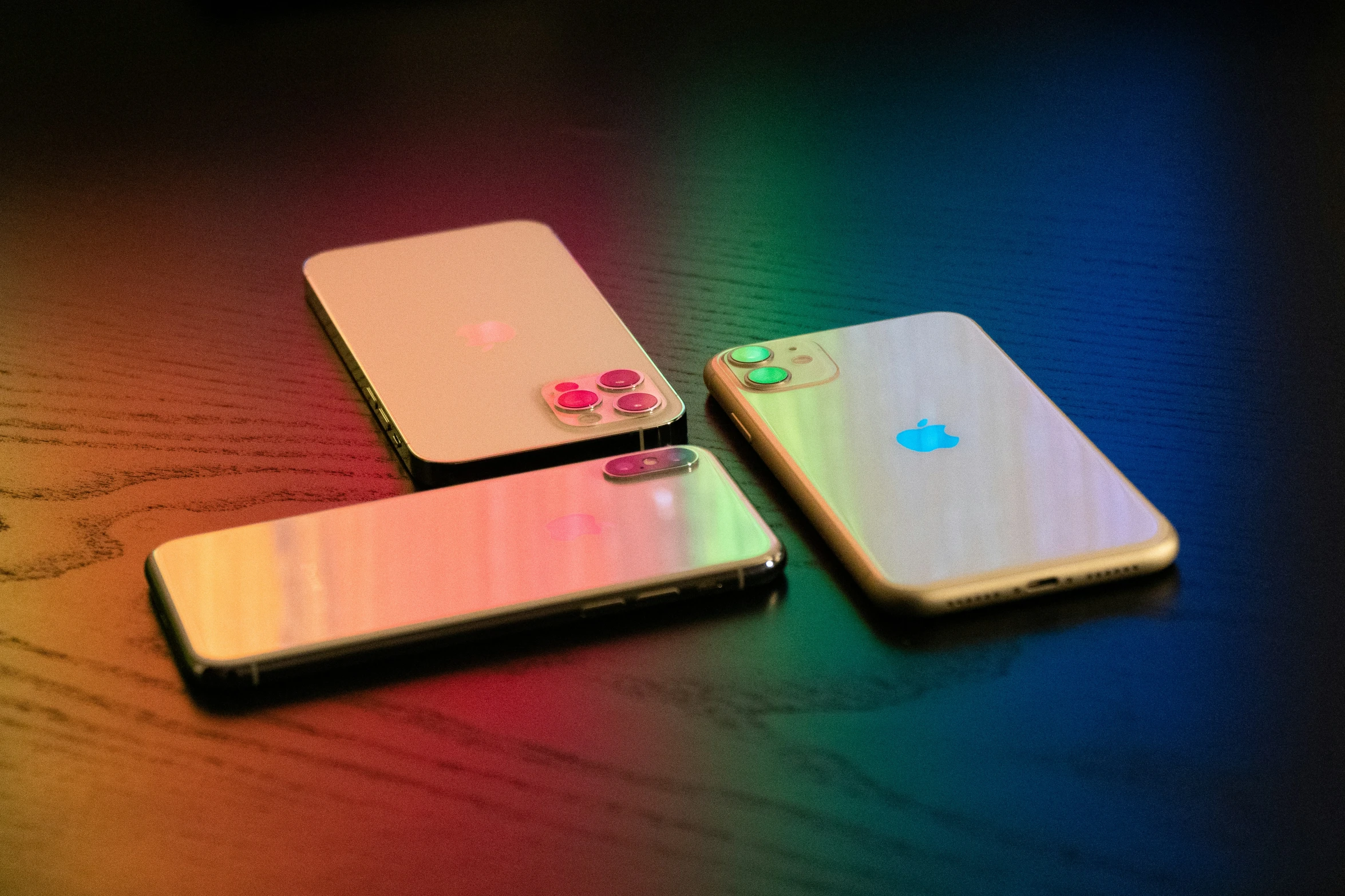 three different cell phones side by side sitting on the table