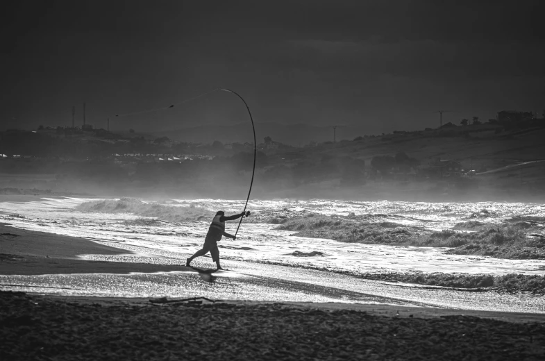 a person standing on a beach holding a surfboard