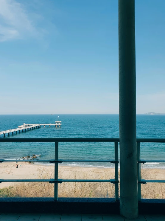 the ocean has a pier near a body of water