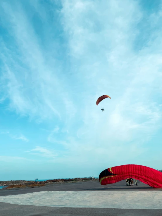 two people in the middle of a field looking at a kite in the sky