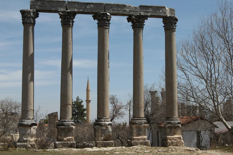 a bunch of old pillars standing next to a building