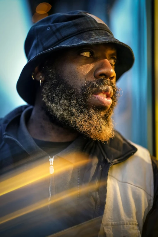 man with beard and hat looking off to the side