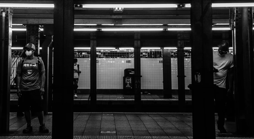 two men standing next to each other at the train station