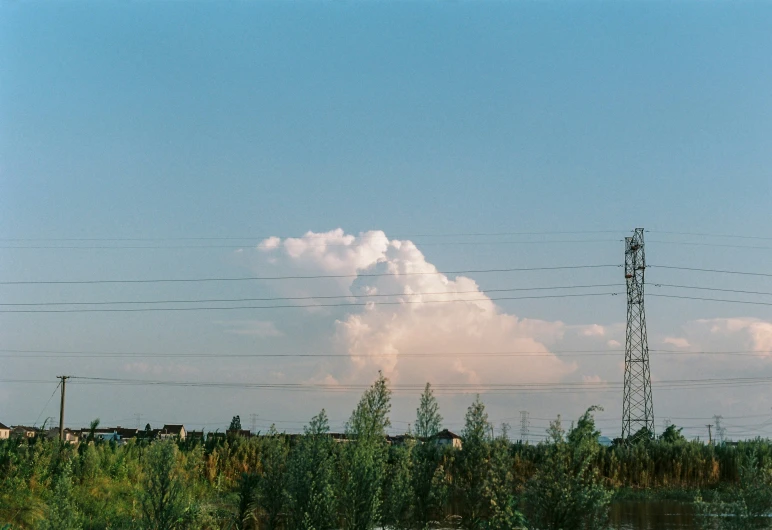 power lines in the foreground with cloudy skies and water in the background