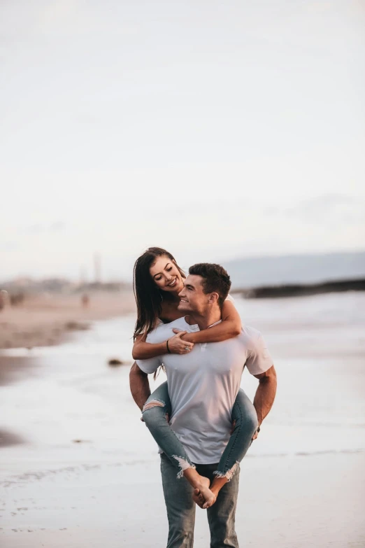 a man and woman walking along the shore with each other