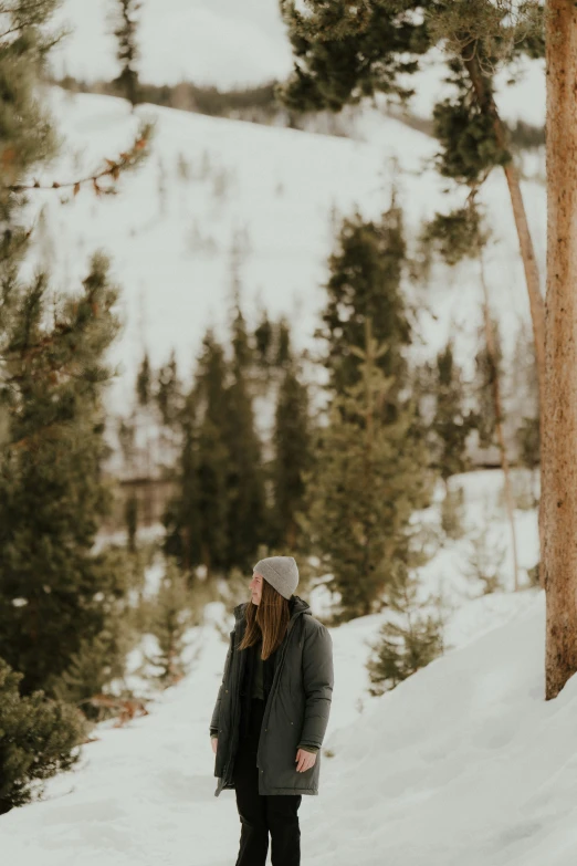 a woman is standing in the snow with her arms wide open