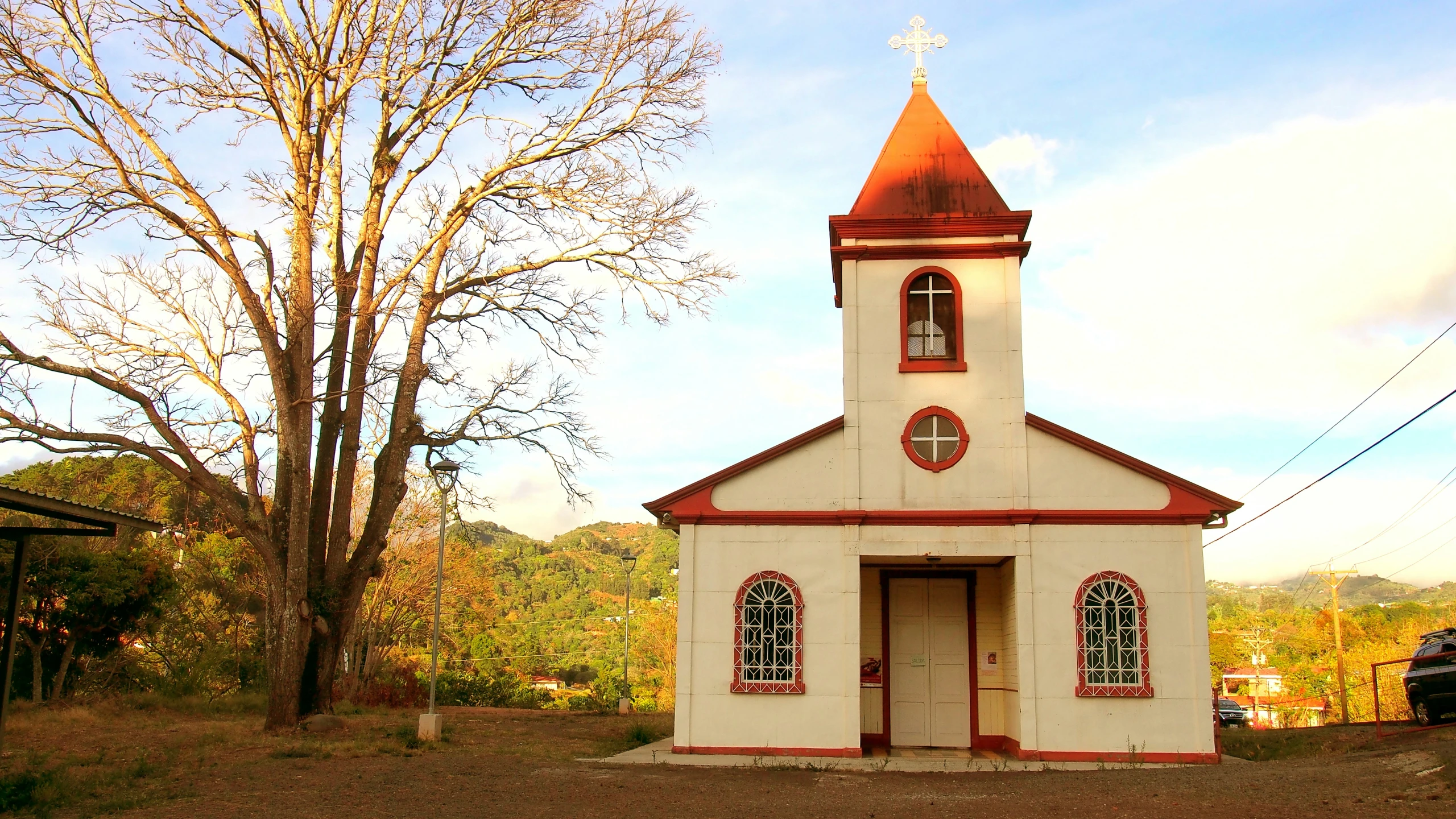 an old white church with red and gold accents