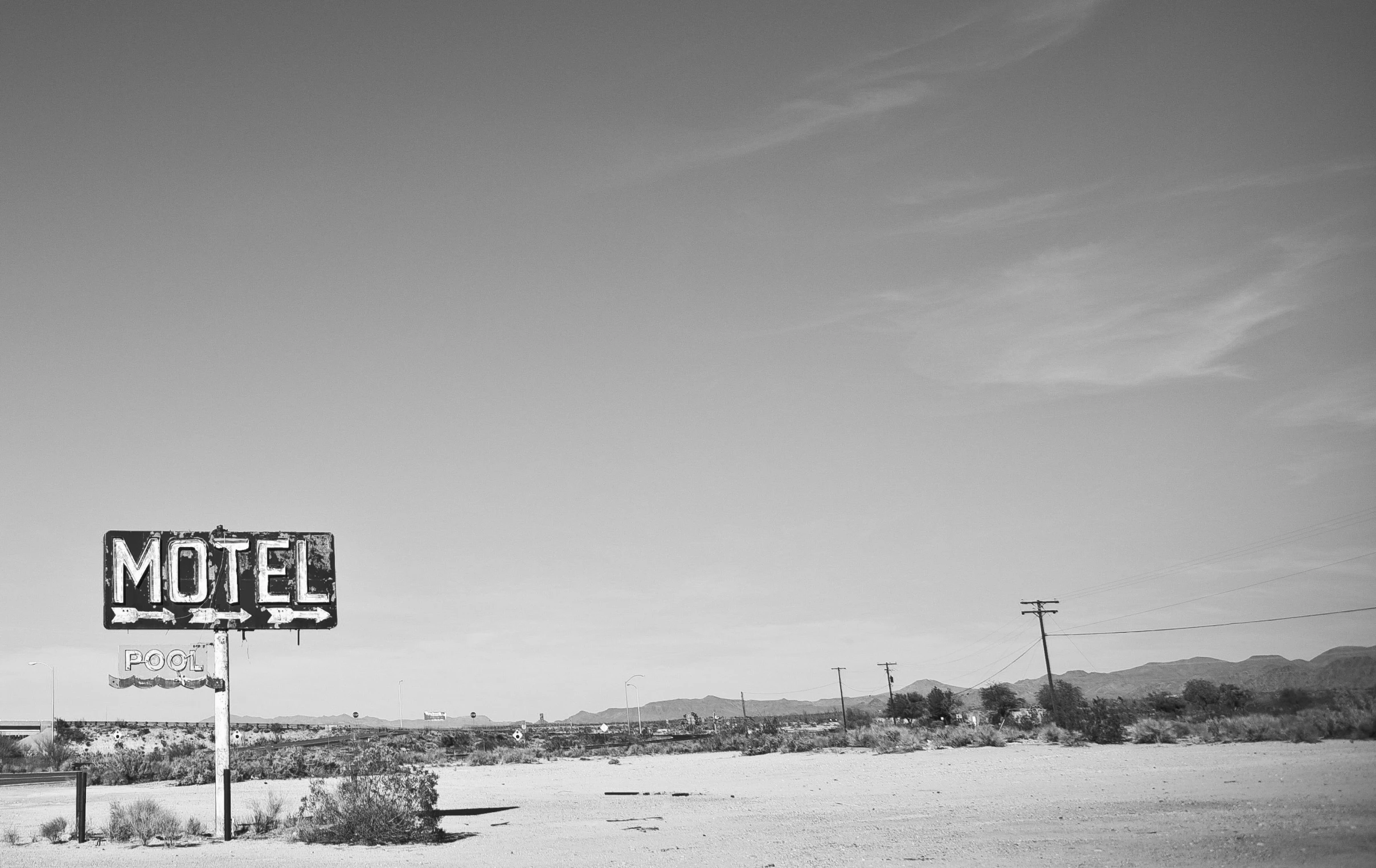 a motel sign next to an abandoned building