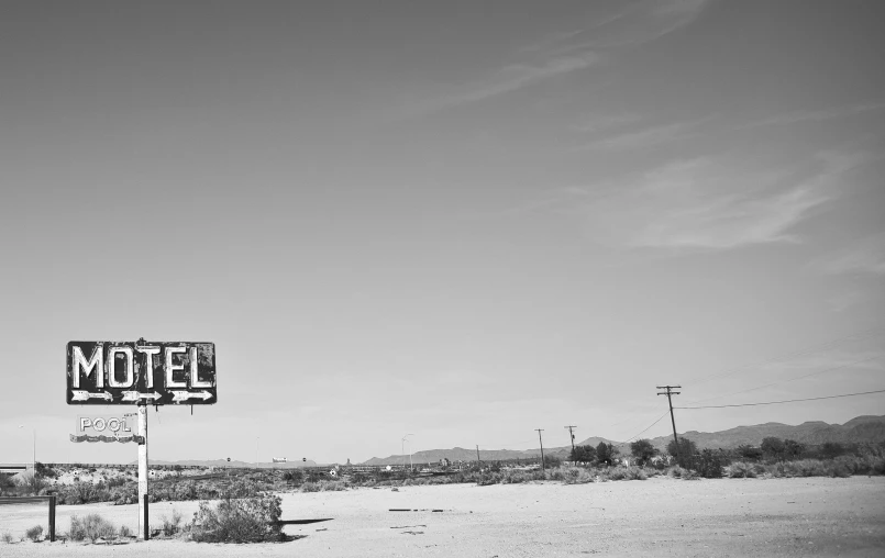 a motel sign next to an abandoned building