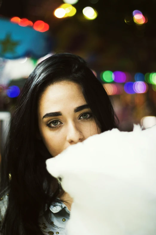 a woman with long black hair and light colored lights behind her