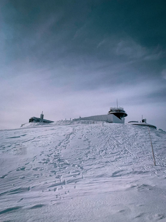 two vehicles are parked on top of the snowy hill