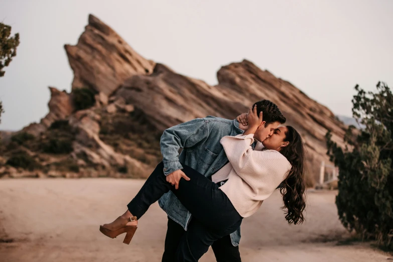 a couple cuddling in front of a mountain