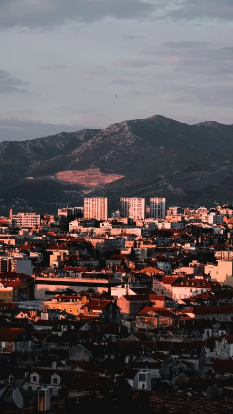 a large city in the foreground surrounded by mountains