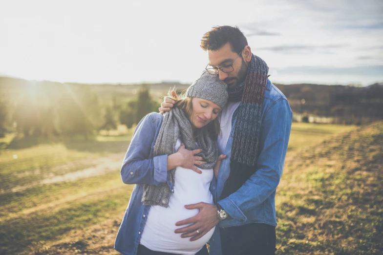 an pregnant woman and a young man in a pasture