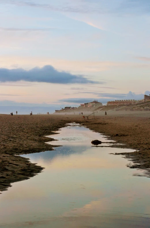 a body of water at a beach with clouds in the background