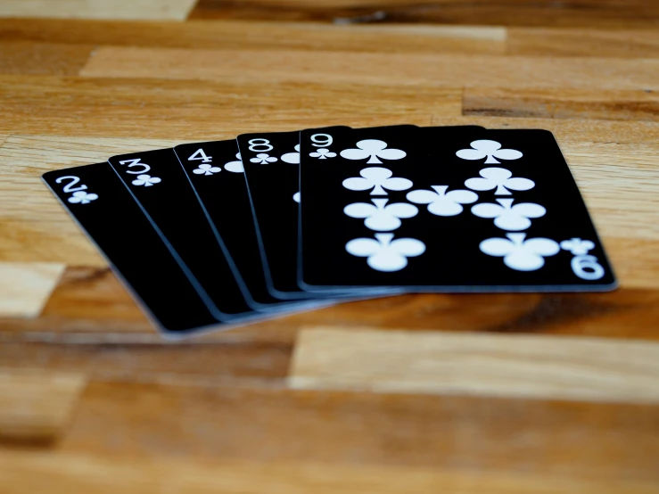 four deck of cards, on a wooden surface