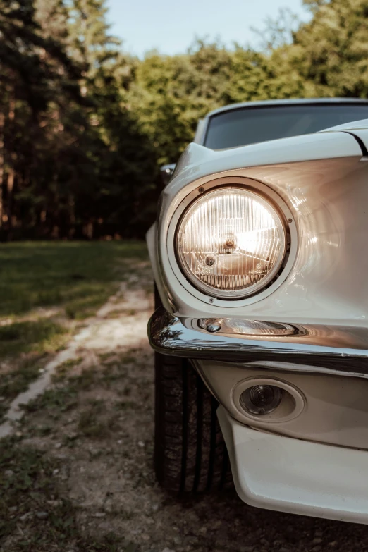 the headlights of an old car parked on the side of a road