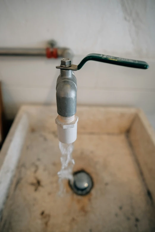 a faucet and toothbrush sitting on top of a sink