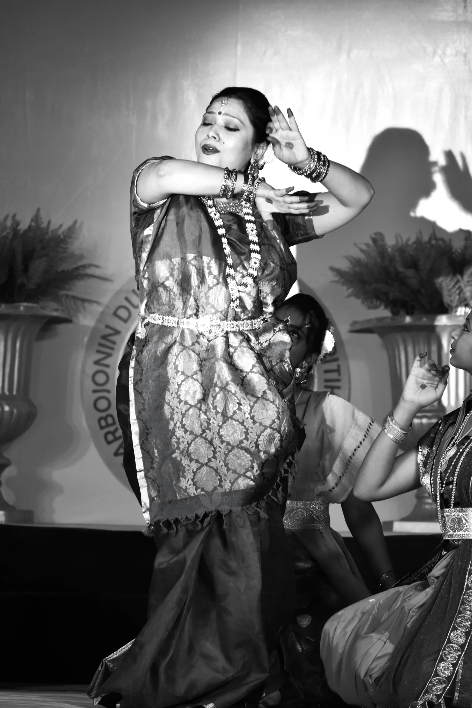 a woman is performing dance with another woman nearby