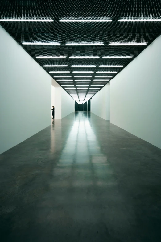 a man stands alone in the empty museum space