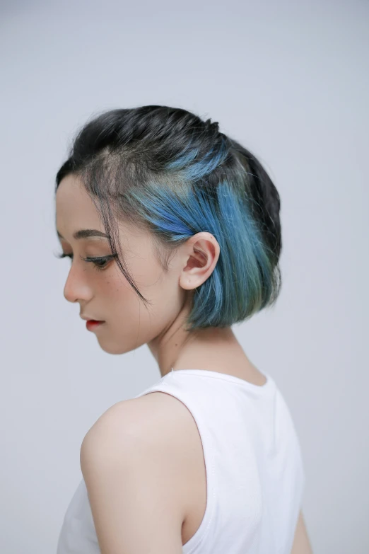 a woman with blue and black hair is staring down