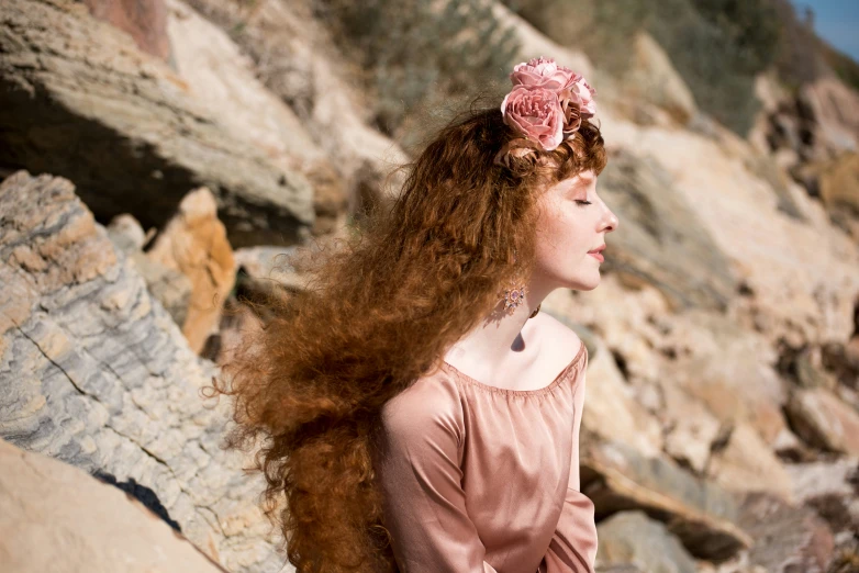 woman with long red hair and flower in her hair