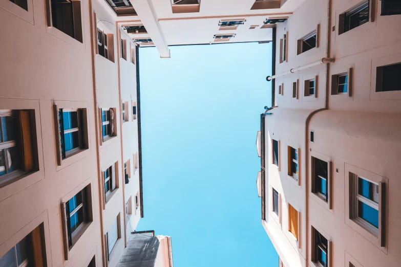 a tall narrow building with windows overlooking the sky