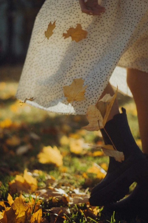 a close up of a person walking with her umbrella and boots