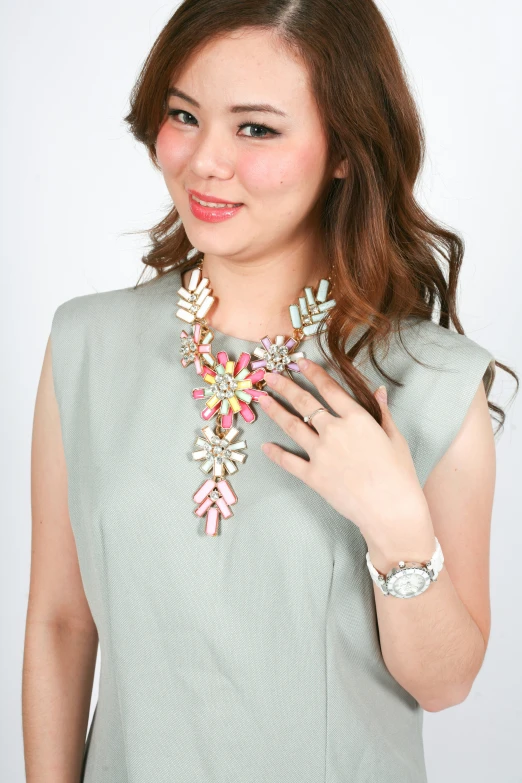 a close up of a woman holding a colorful necklace